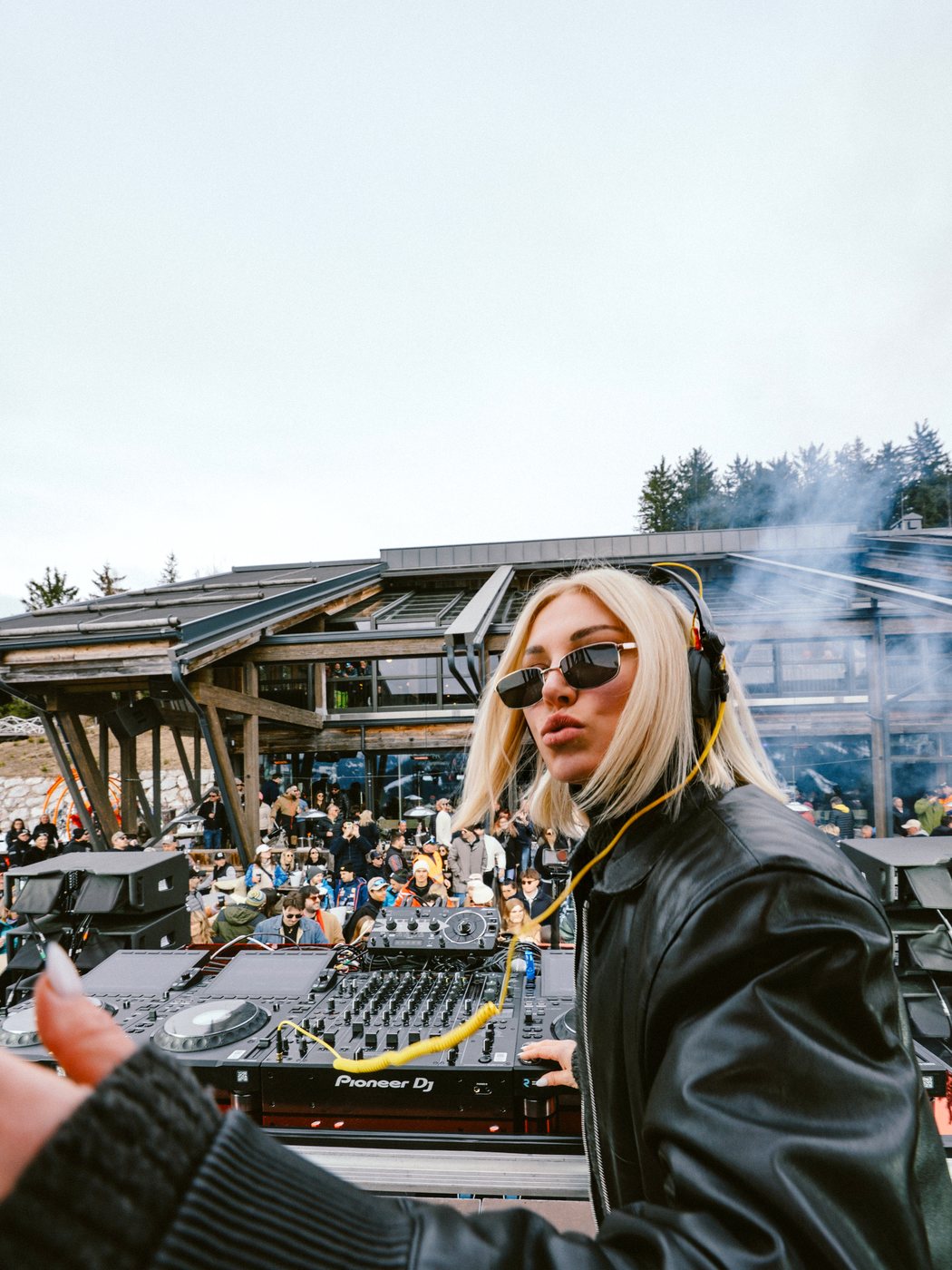 Dominique Jardin at the decks at tom Almhütte, wooden chalet behind