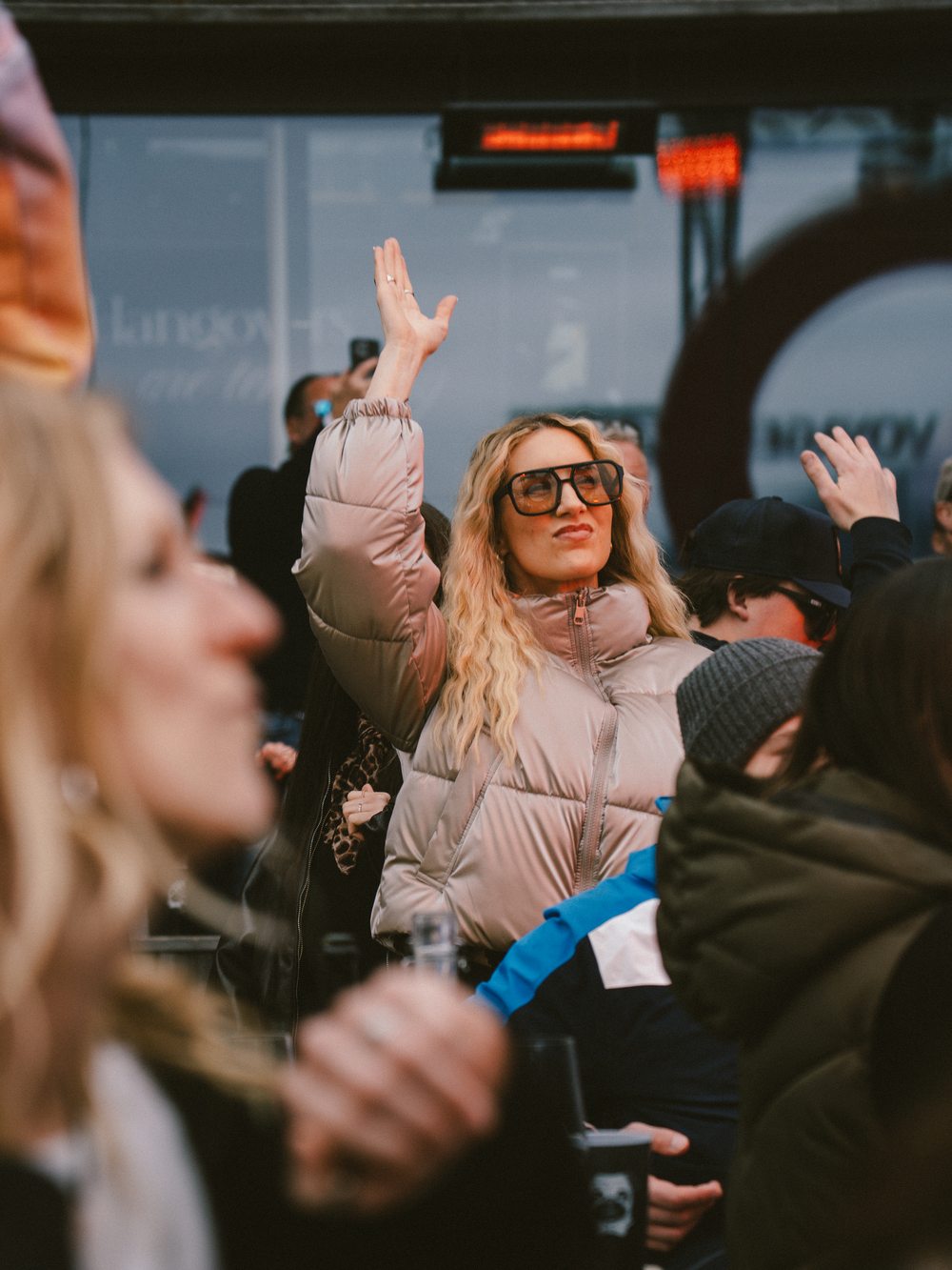 Guest in the crowd with hands up at tom Almhütte, dusk